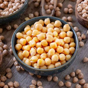 cooked and raw chick peas on wooden table