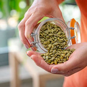 woman eating fresh organic pumpkin seeds