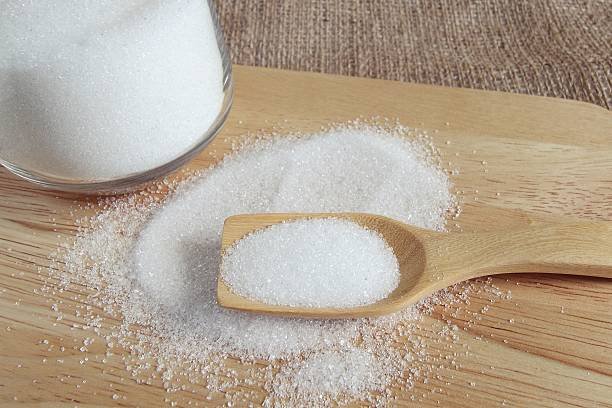 white sugar in wood spoon