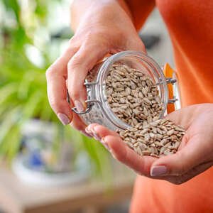 woman eating fresh organic sunflower seeds